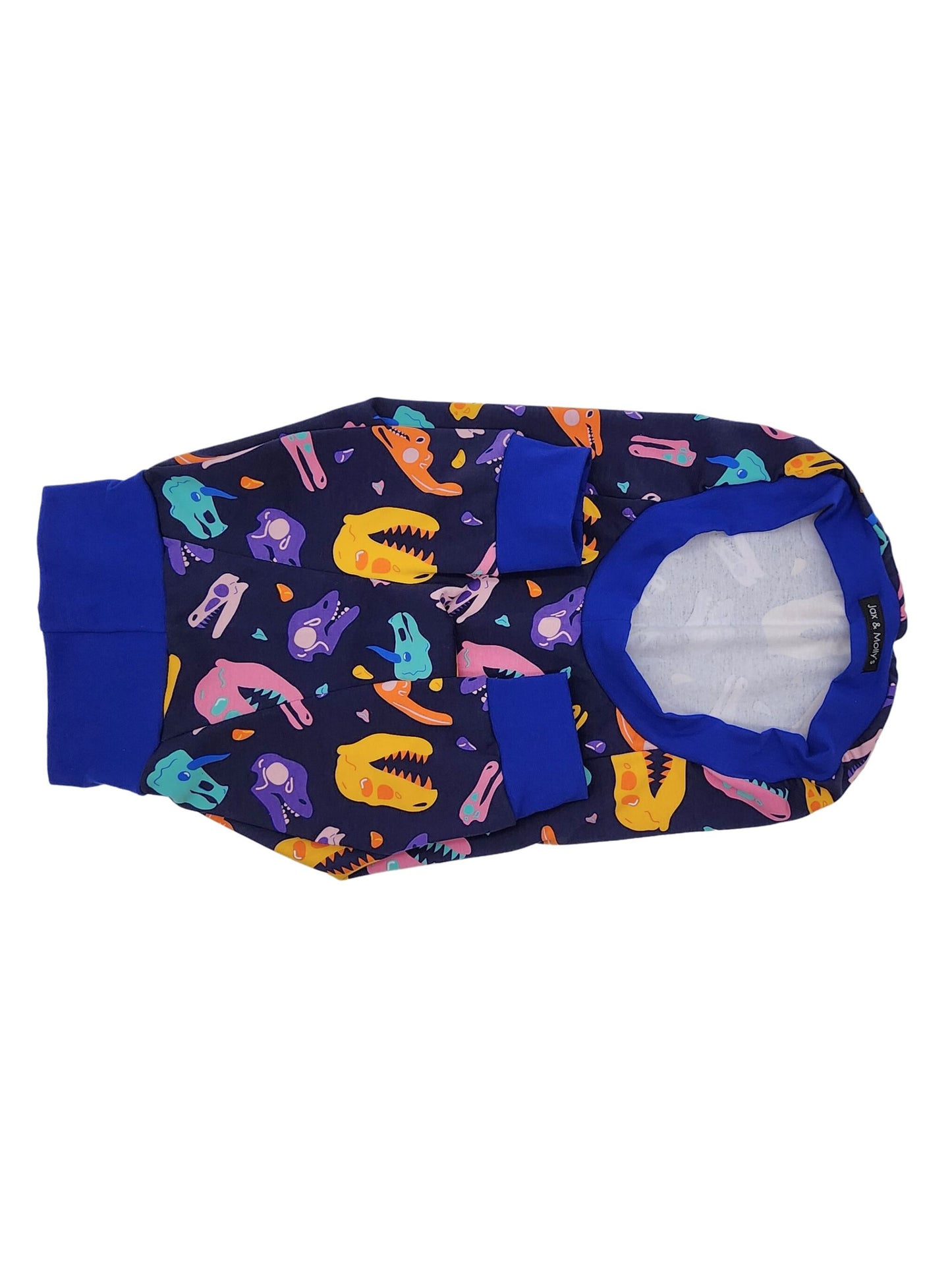 Underbelly view of blue raglan dog pajamas adorned with colorful dinosaur skull complemented by royal blue trim.