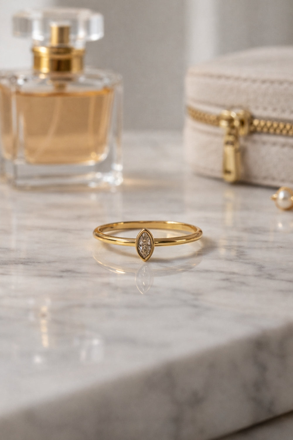 Stackable marquise gold ring 18k PVD stainless steel ring on marble surface lifestyle scene