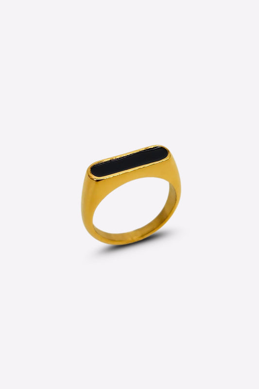 Side profile of a stunning gold ring featuring a raised oblong black enamel setting that serves as its centerpiece.