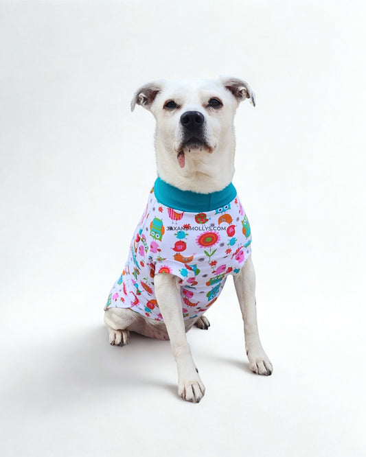 Medium white dog wearing cotton owl dog pajamas, front view showing chest fit and neckline
