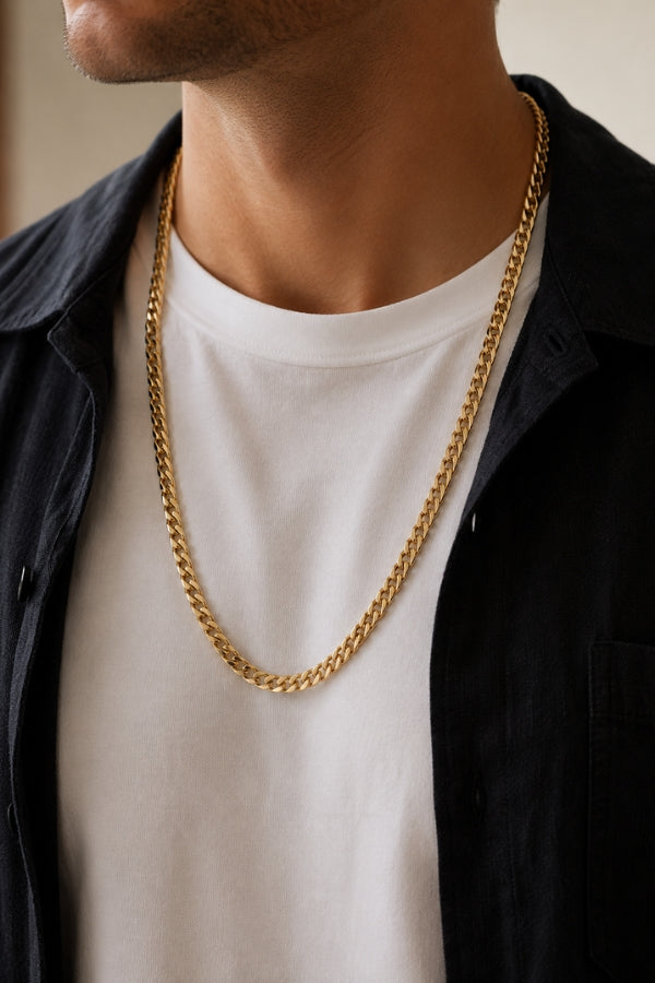 Man wearing the 8mm Cuban Link 18K Gold PVD Necklace with a white t-shirt and black overshirt, showcasing the 26-inch length.