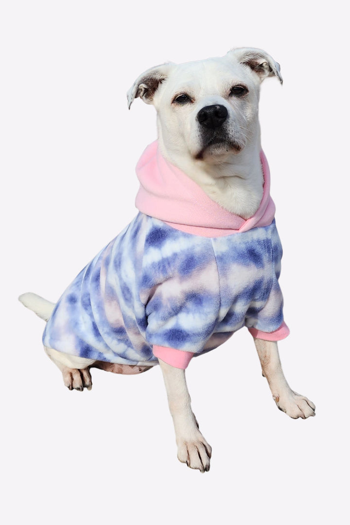 Adorable white pup modeling Jax & Molly's Cotton Candy Tie-Dye Fleece Dog Hoodie with gorgeous hues of lavender, pink and white fleece and complimented by a baby pink hood.