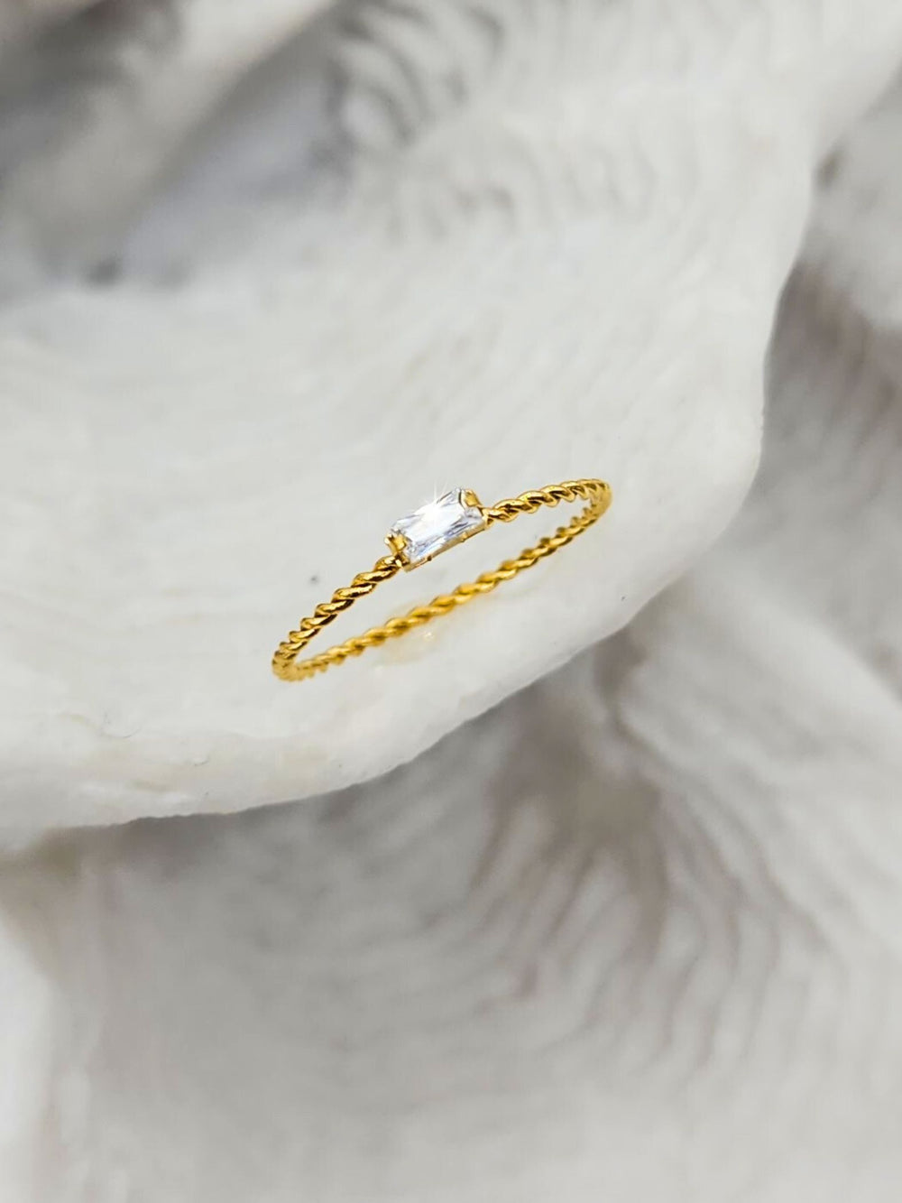 Jax & Molly's 18K Gold PVD Plated Rectangular Gemstone Ring with Twisted Band on a white coral display.