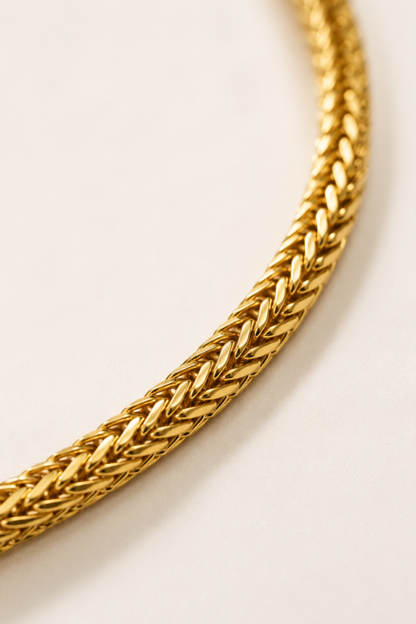 Close-up of gold Franco chain links showing the detailed woven construction and polished finish