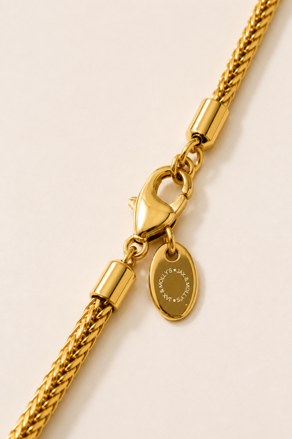 Logo Tag
Close-up of gold Franco chain lobster clasp and Jax & Molly’s engraved logo tag