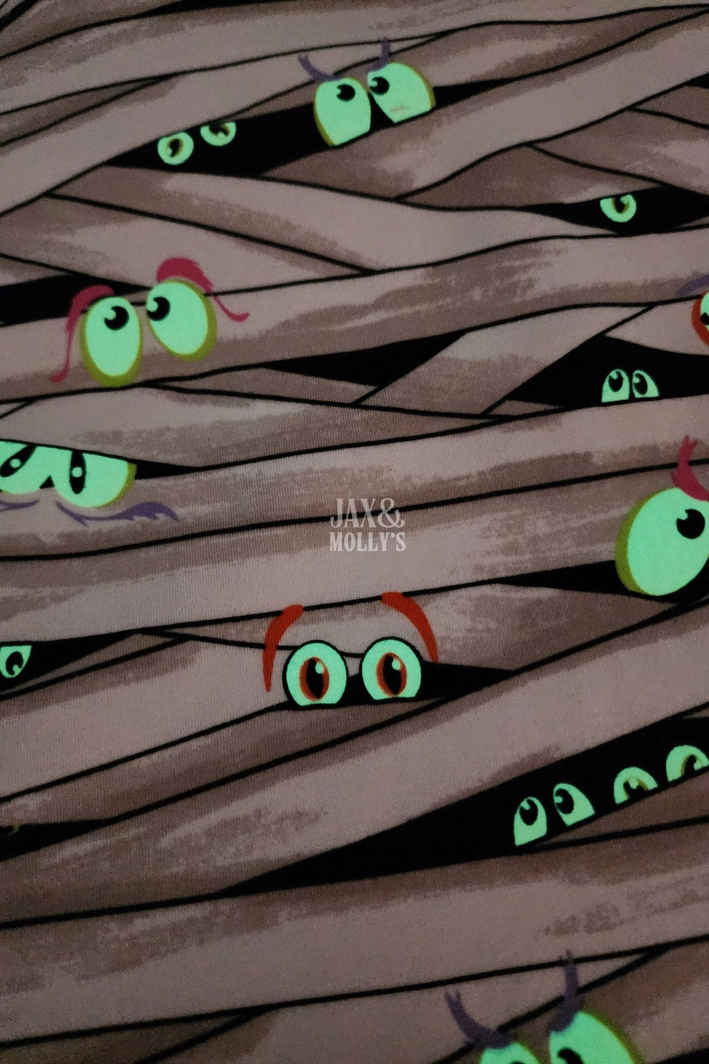 Glow-in-the-dark Fabric with eyes peeking out from behind woven strands 