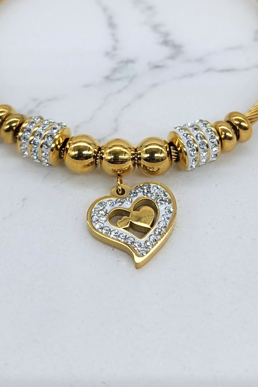 Close-up of Jax & Molly's 18k gold plated bracelet featuring a cable design with gorgeous heart pendant adorned with crystals.