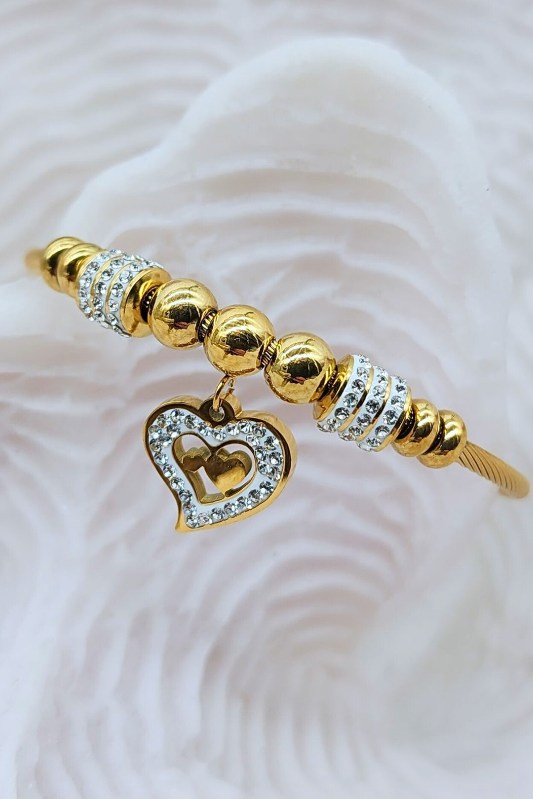 Close-up of Jax & Molly's 18k gold plated bracelet featuring a cable design with gorgeous heart pendant adorned with crystals.