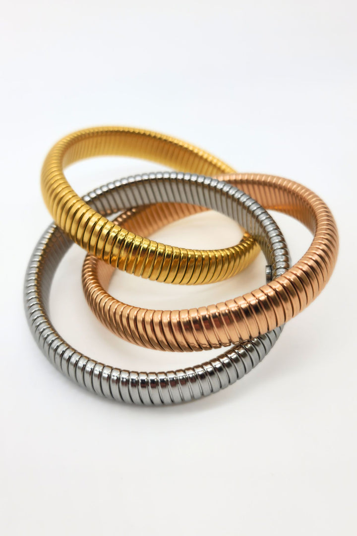 Jax & Molly's captivating set of three interlinked stretch snake bracelets in steel, rose gold, and gold.