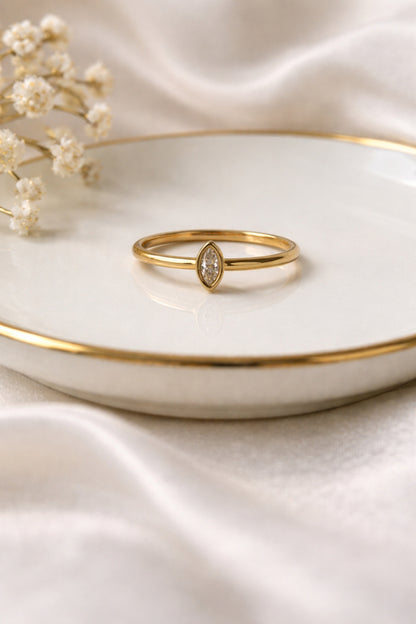Minimalist marquise gold ring 18k PVD stainless steel ring on ceramic dish soft neutral styling