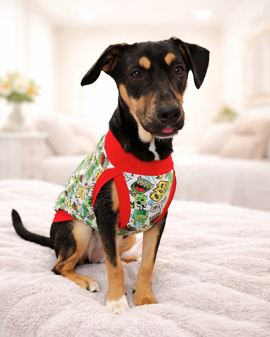 Green graffiti goblin lightweight poly-spandex dog pajamas on black and tan dog, sitting