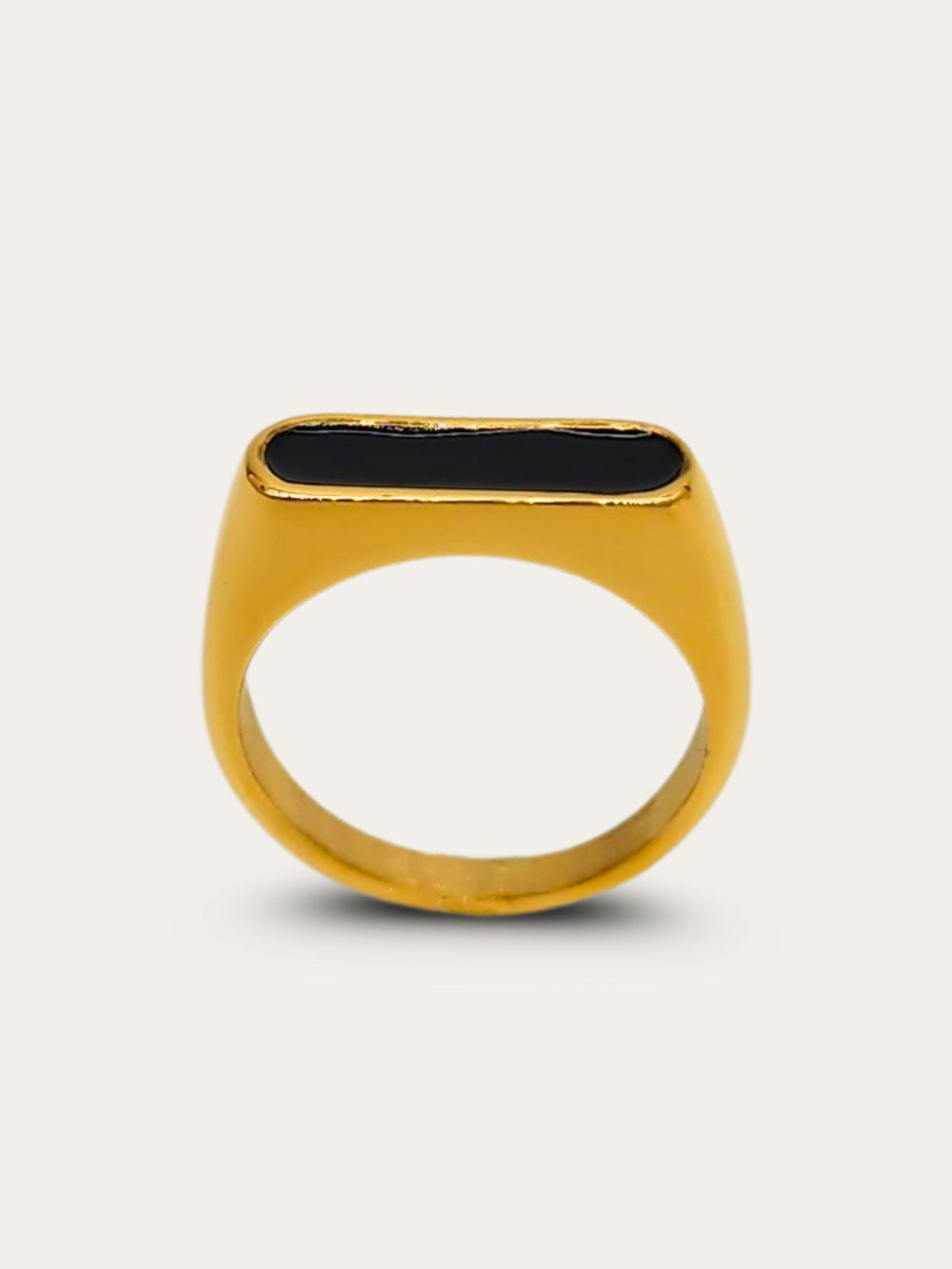 Front view of a gold ring featuring a raised oblong black enamel setting that serves as its centerpiece.