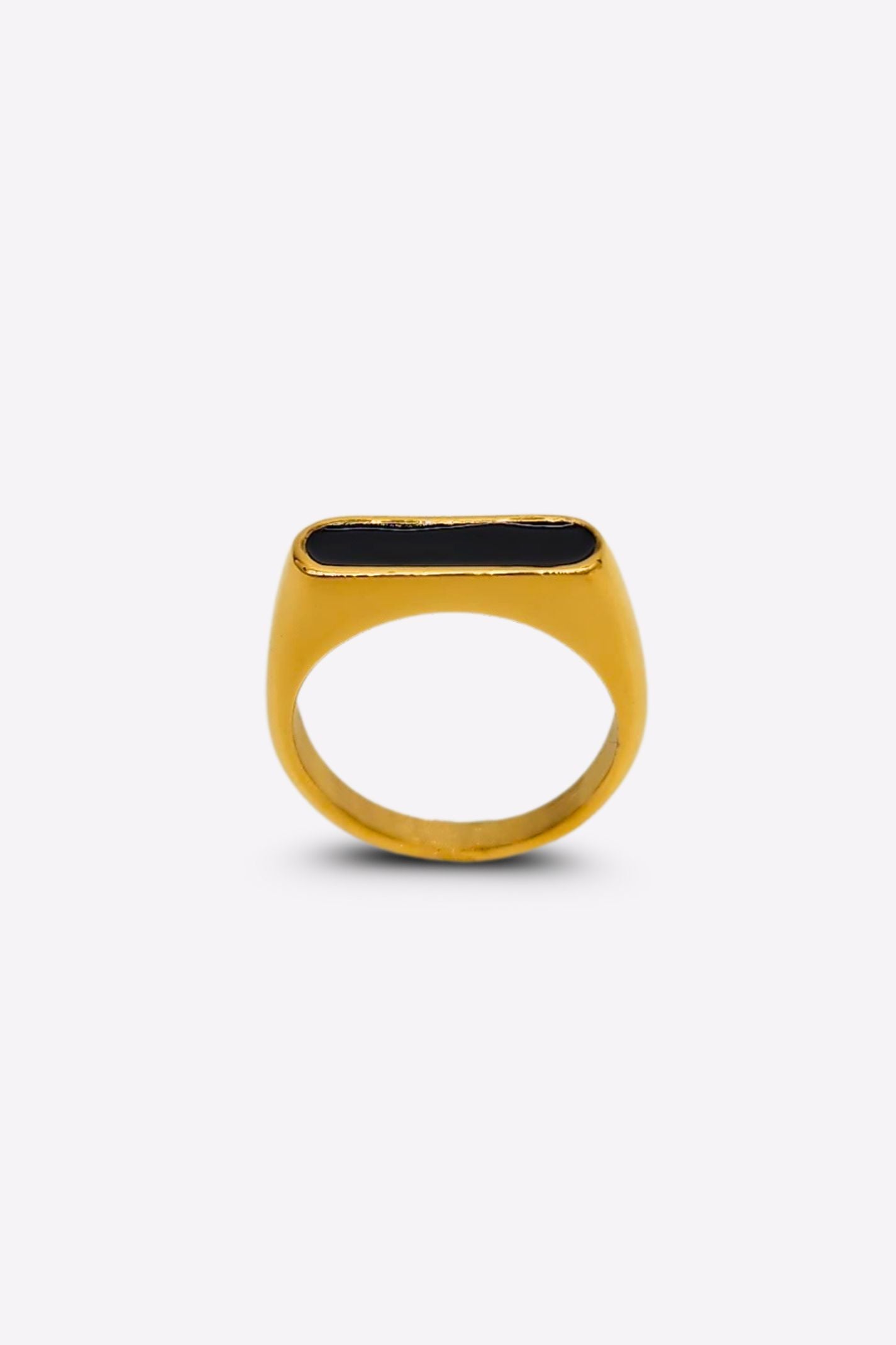 Front view of a gold ring featuring a raised oblong black enamel setting that serves as its centerpiece.