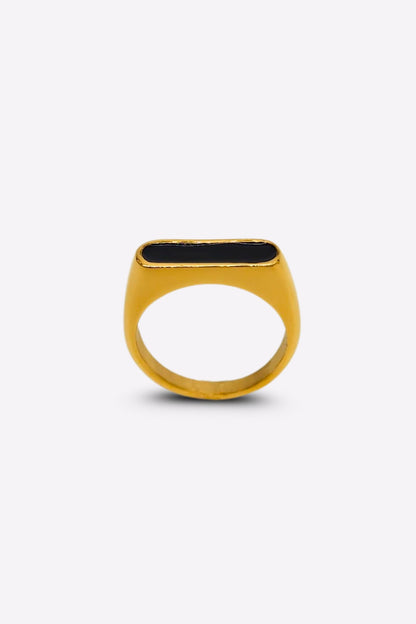 Front view of a gold ring featuring a raised oblong black enamel setting that serves as its centerpiece.