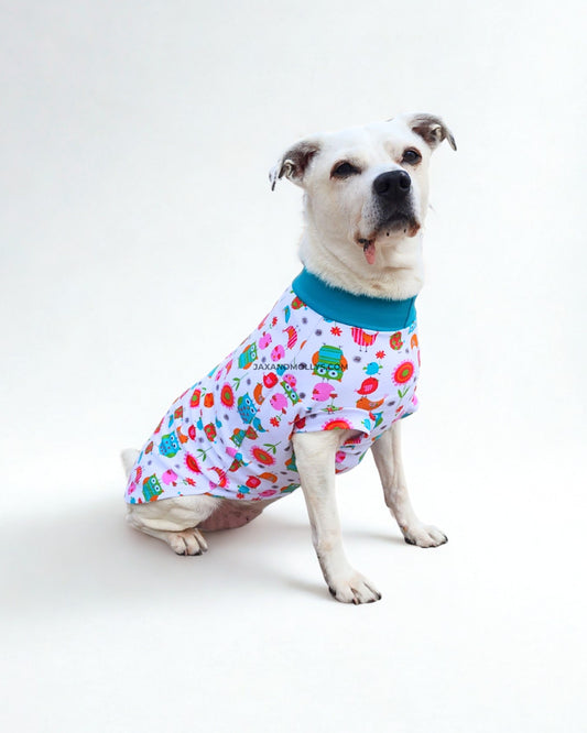 Side view of medium white dog modeling owl print dog pajamas, highlighting stretch fit and sleeve detail
