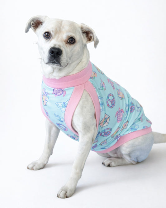 Pastel Ocean Icons cotton-spandex dog pajamas with light pink trim on white dog, sitting side view
