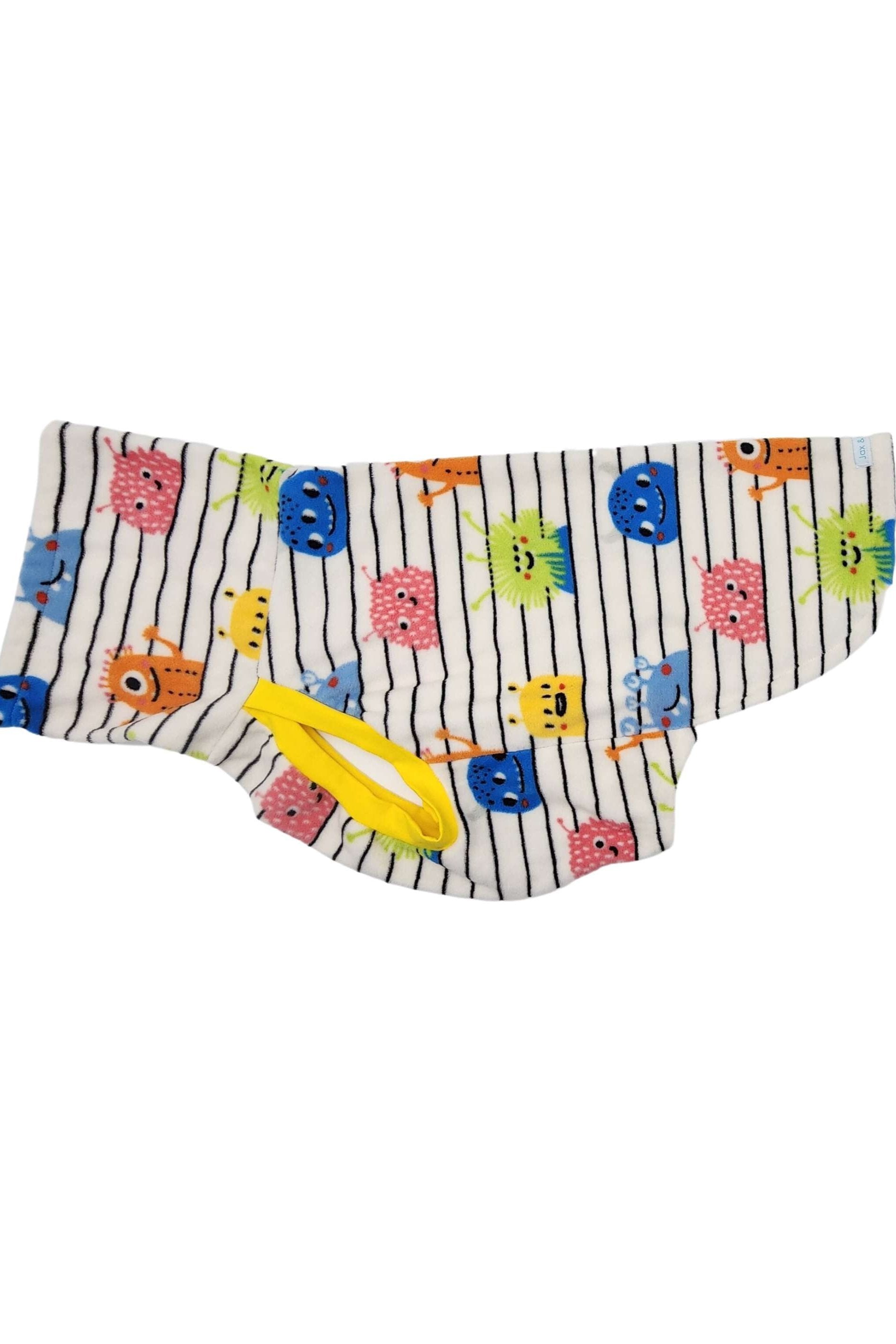Side view of a fleece dog sweater with a colorful print of monsters