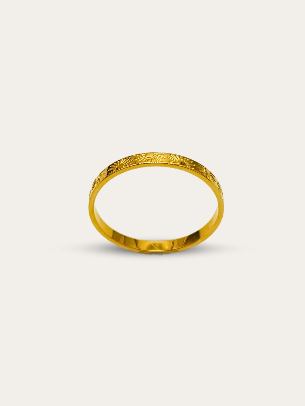 Elegant gold ring featuring sun and ray inscriptions, captured from a front angle on a white background.