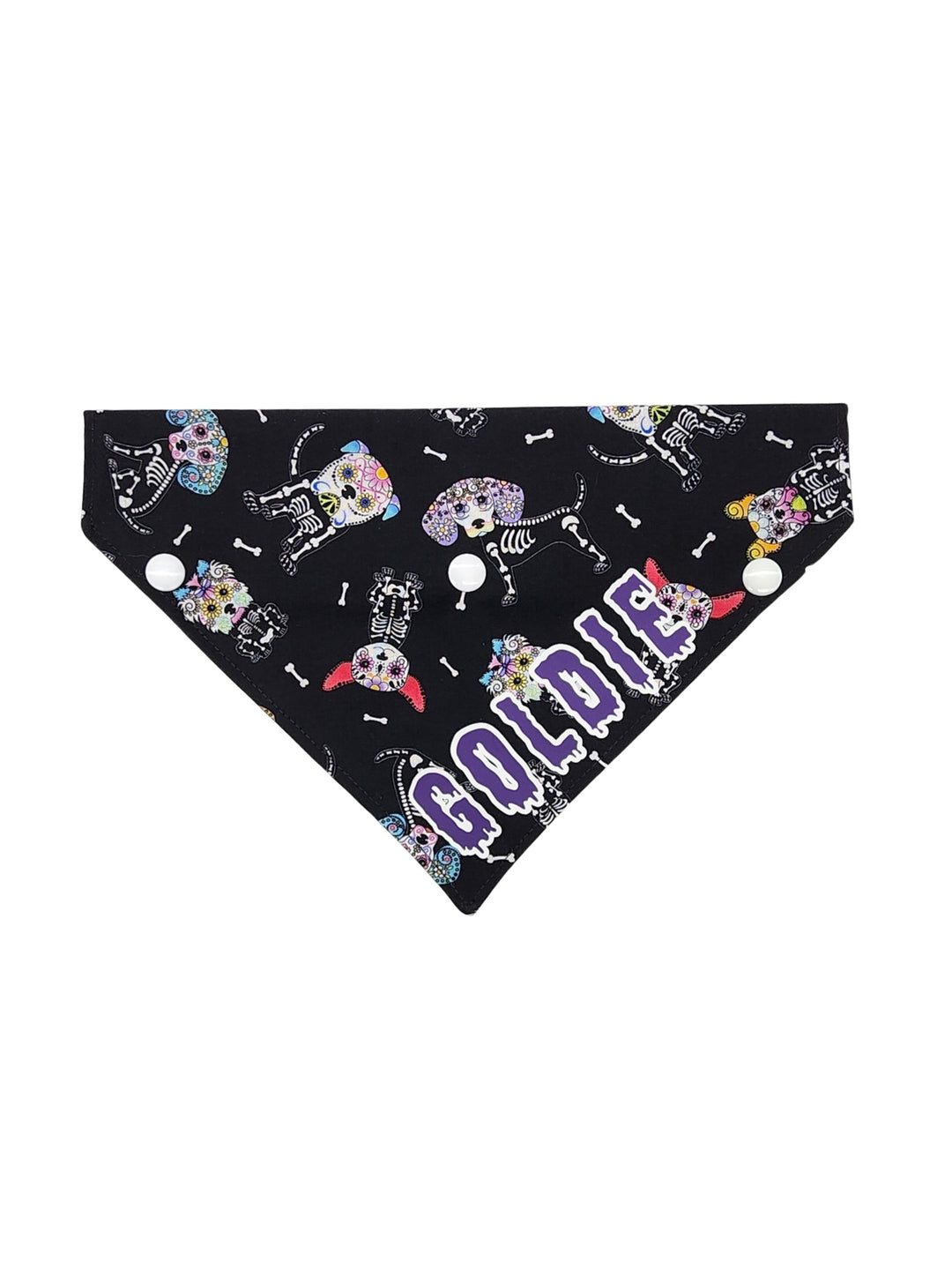 Front profile of a black halloween dog bandana featuring a sugar skull dog skeleton pattern and a purple graphic that reads the name Goldie.