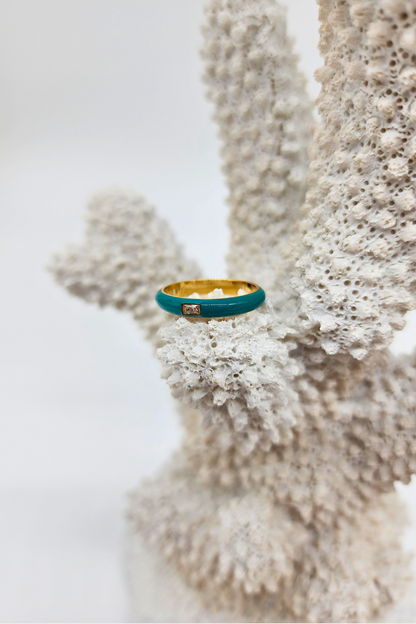 Elegant Teal Enamel Gemstone Ring displayed on white coral, capturing the harmonious blend of the teal enamel band, 18k PVD Gold Plated stainless steel, and the eye-catching rectangular gemstone.