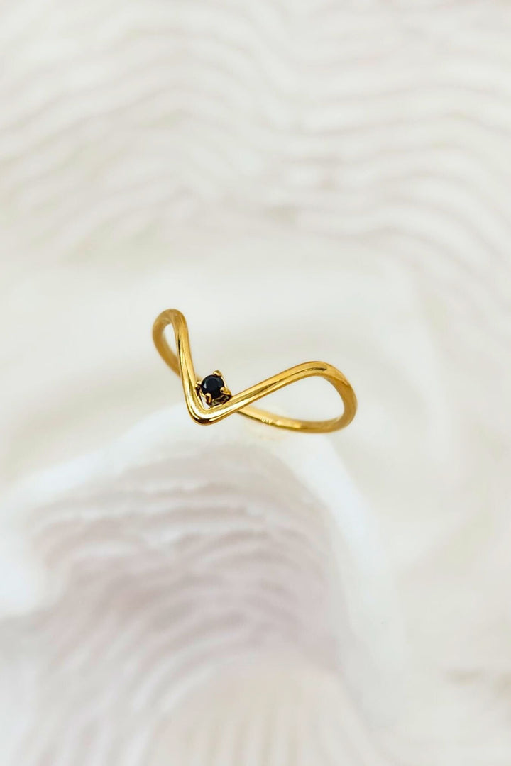 Thin v-shaped gold ring with black onyx stone at the tip. 