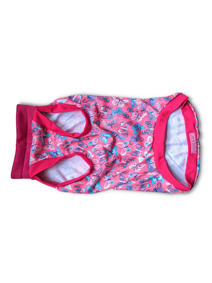 Underbelly view of pink dog pajamas with butterfly print with fuchsia trim