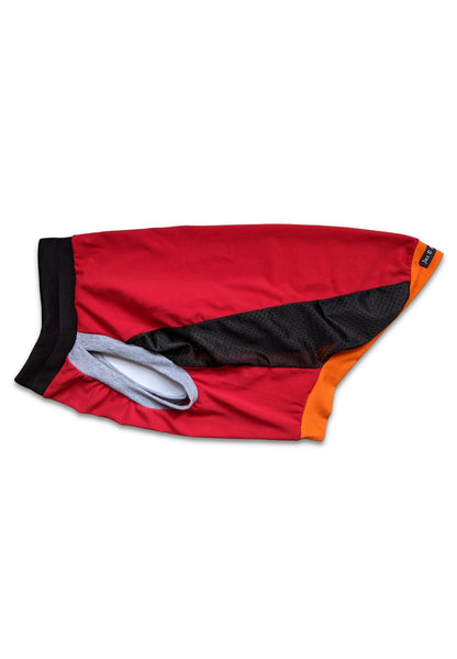 A red, black, orange, and grey sport jersey for dogs with a muscle tank design, featuring large armholes and a black neckline with grey trim. It also shows an orange waist cuff.